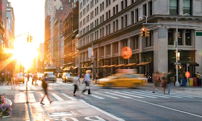 Yellow taxi moving through a Manhattan street